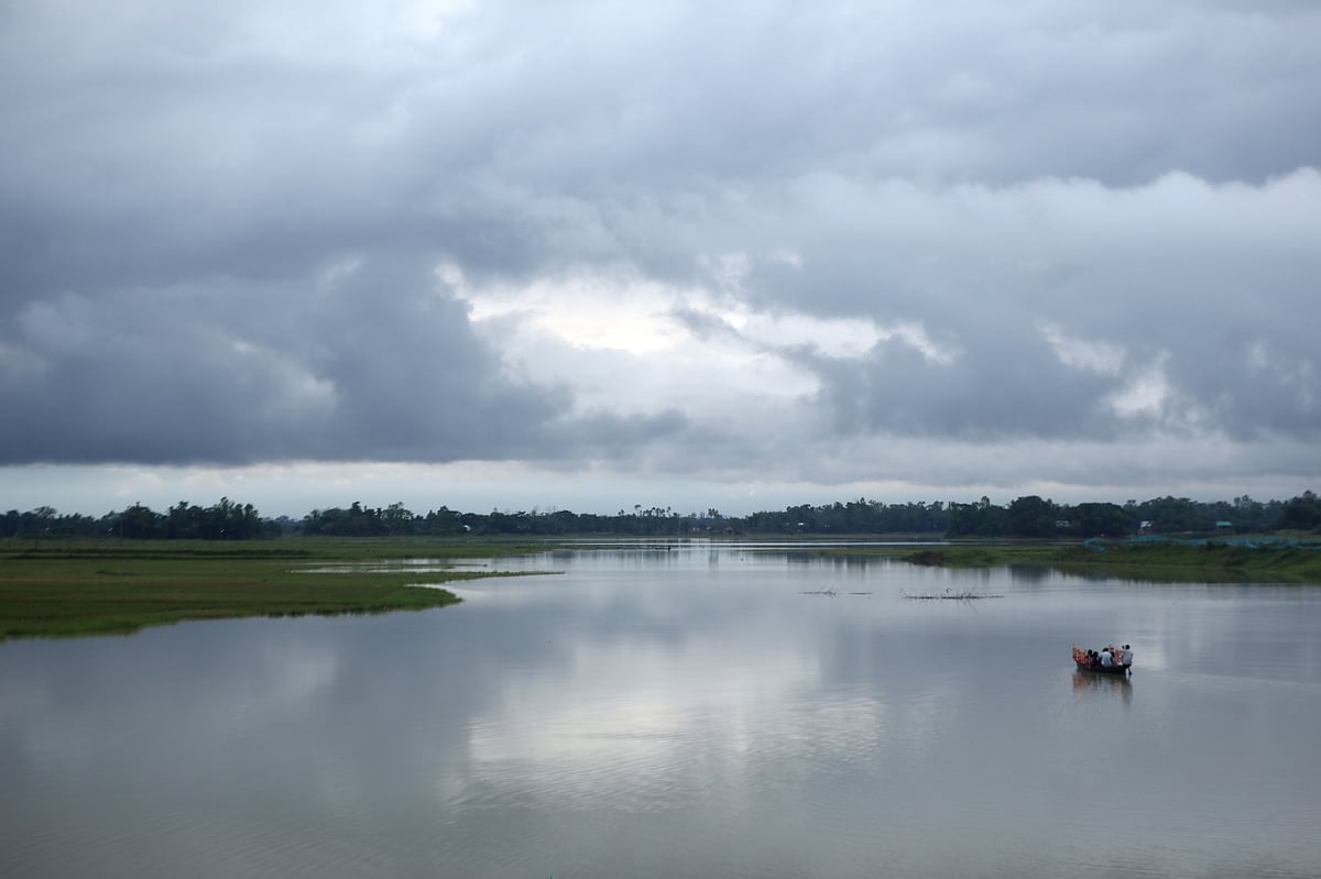 আকাশজুড়ে মেঘের ঘনঘটা। টানা বৃষ্টিতে হাওরে জমা হওয়া নতুন পানিতে চলছে নৌকা। 