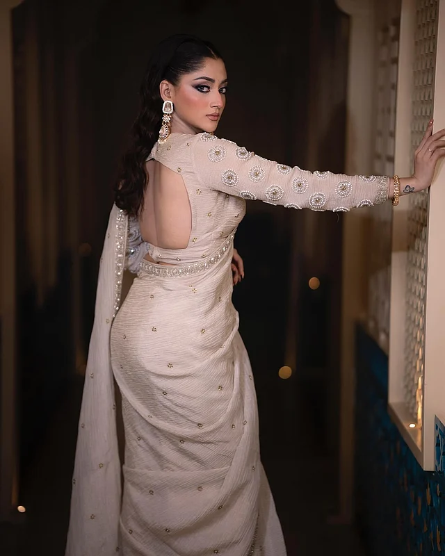 মিনিমাল শাড়ির সঙ্গে একই রঙের সুইটহার্ট নেকের ফুলস্লিভ ব্লাউজ পরেছেন পূজা। ব্লাউজে মুক্তা আর সিকুইনের নিখুঁত কারুকাজ। আকর্ষণ কাড়ছে ব্যাকলেস ডিজাইন