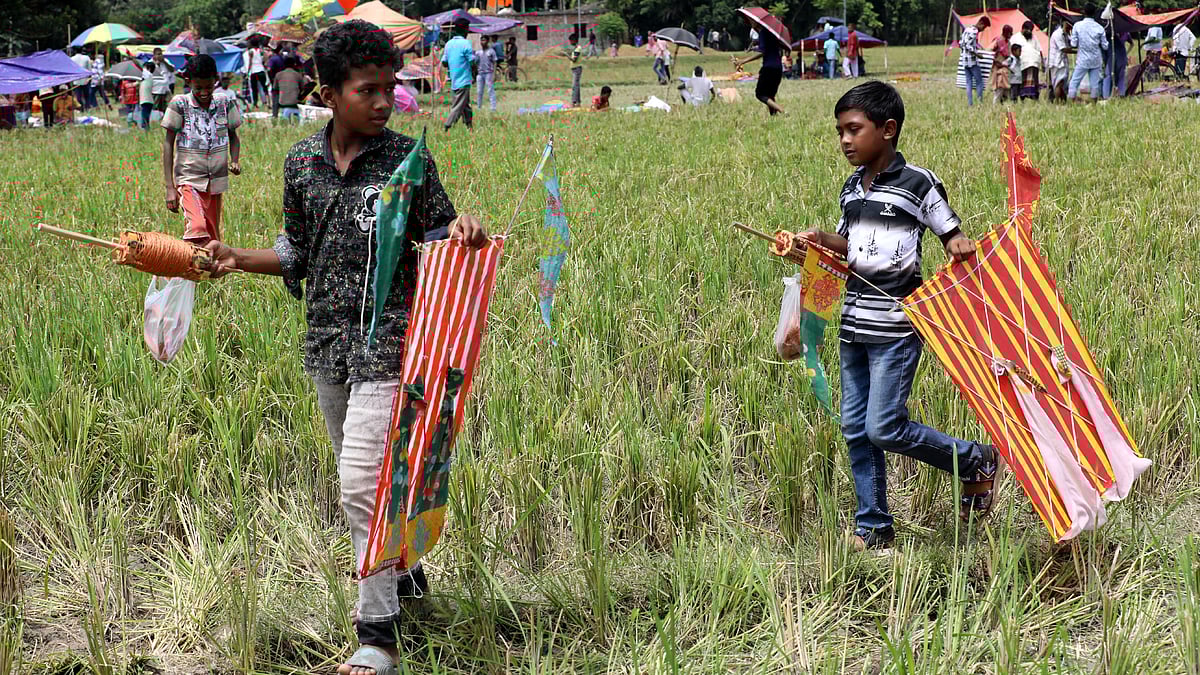 রঙিন ঘুড়ি, নাটাই ও সুতা হাতে মেলায় দুই শিশু