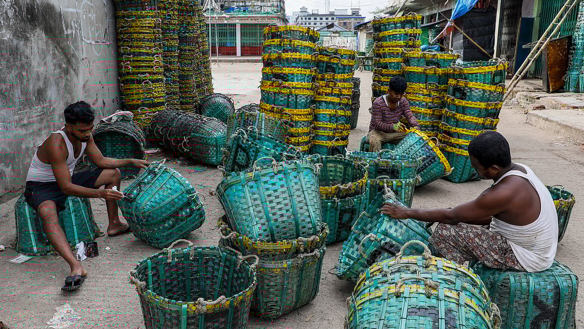 মাছ রাখার টুকরি রং করছেন কয়েকজন জেলে