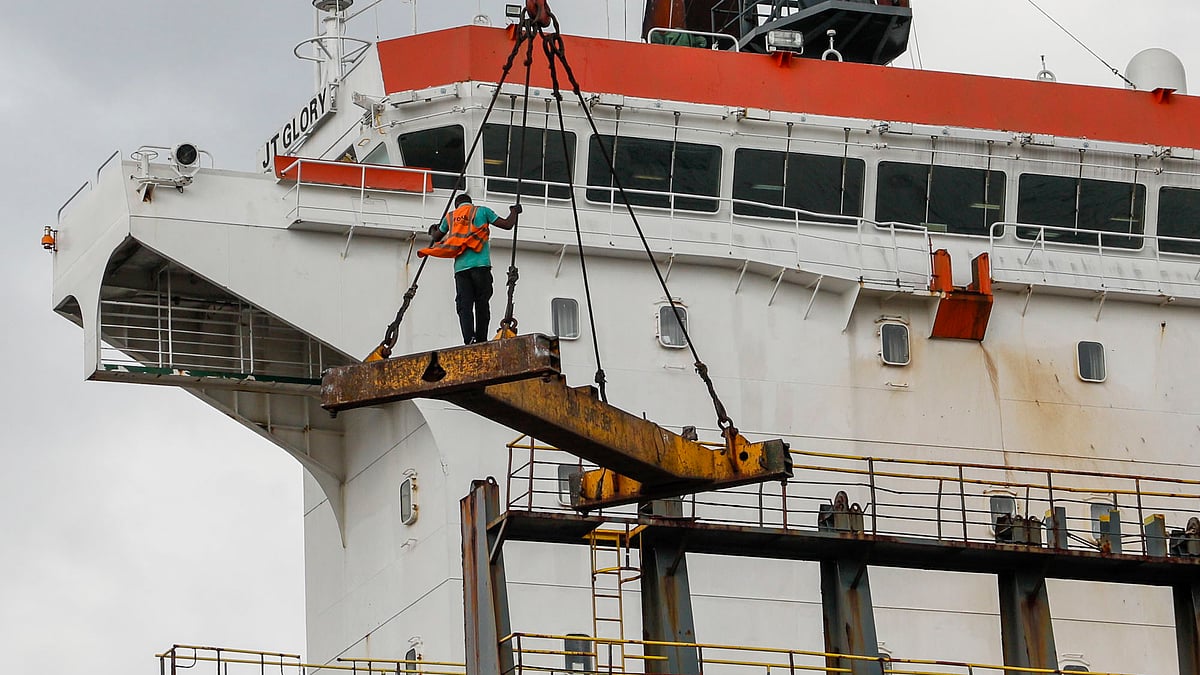 স্প্রেডারে দাঁড়িয়ে জাহাজে উঠছেন এক শ্রমিক