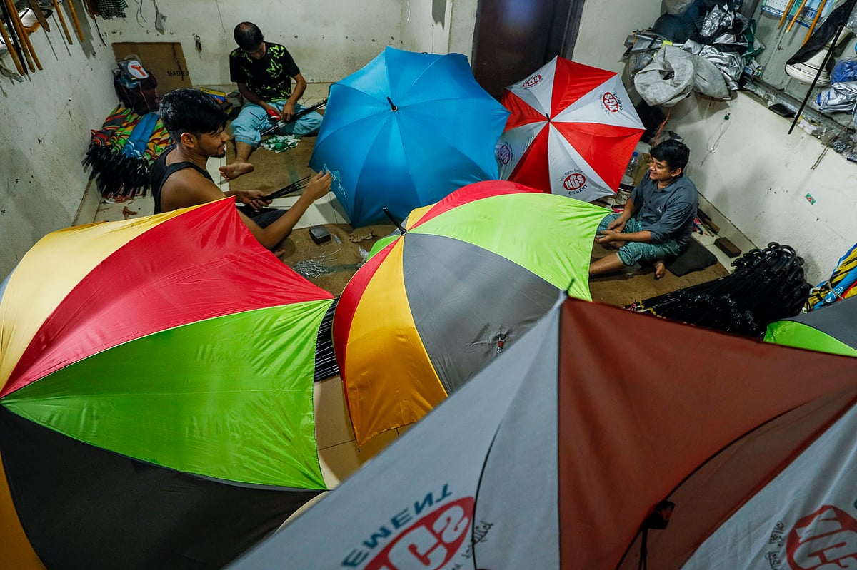 কারখানায় ছাতা তৈরি করছেন কয়েকজন।