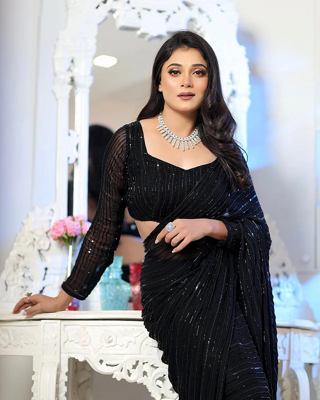 সিকুইনের কাজ করা কালো শাড়ির সঙ্গে ম্যাচিং ফুলস্লিভ ব্লাউজ পরেছেন প্রিয়াঙ্কা । আকর্ষণ কাড়ছে ডায়মন্ডের নেকপিস আর আংটি।