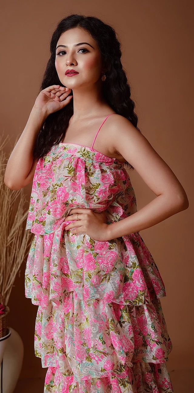 স্লোরাল ড্রেসে আকর্ষণীয় লাগছেন ঐশ্বর্য। স্প্যাগেটি স্ট্র্যাপের গোলাপি ফুল আর অলিভ সবুজ পাতার প্রিন্টের ড্রেসে টিয়ার্ড ডিজাইন। 
