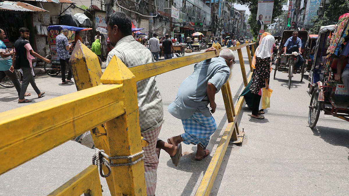 সড়ক বিভাজকের ভাঙা অংশের ফাঁক গলে পার হচ্ছেন পথচারীরা।