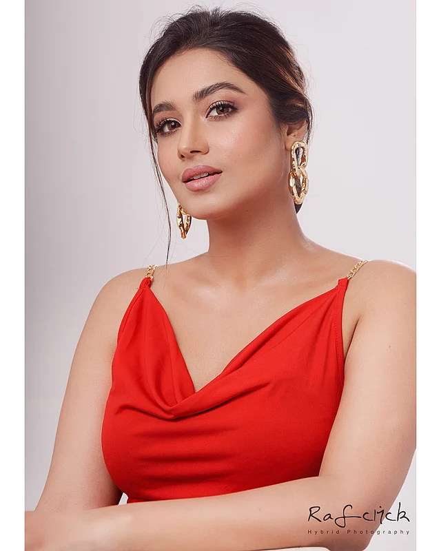 কাউল নেকলাইনের লাল স্লিভলেস ড্রেসে ফারিণকে অন্য রকম সুন্দর লাগছে। পোশাকের স্লিভে থাকা সোনালি চেইনের সঙ্গে মিলিয়ে তিনি বেছে নিয়েছেন সোনালি জুয়েলারি। কানে চেইন প্যাটার্ন দুল আর হাতে পরেছেন ব্রেসলেট। 
