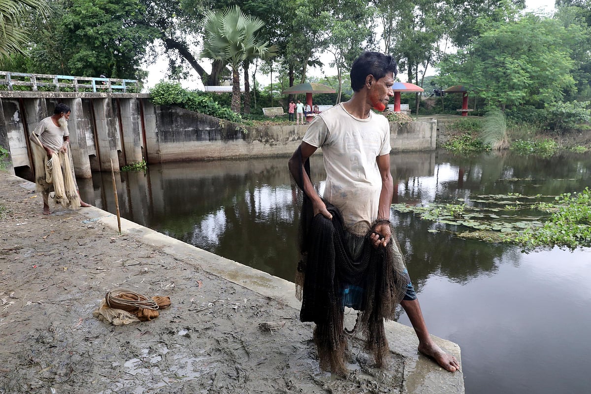 জাল নিয়ে মাছ শিকারের অপেক্ষায়। 
