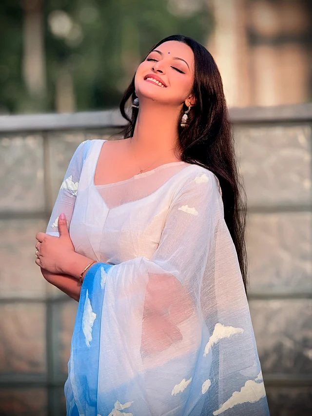 তাঁর স্নিগ্ধ সাজে লুকিয়ে আছে মোহময়ী আমেজ। সাদা-নীল শাড়ির জমিনে হাতে আঁকা মেঘ খেলা করছে, ব্লাউজেও তা–ই ফুটিয়ে তোলা হয়েছে।