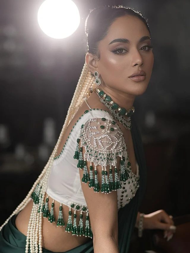 অভিনেত্রীর স্লিক বান হেয়ারস্টাইলে শোভা পাচ্ছে মুক্তার ঝুলে থাকা লম্বা অলংকার, যা আলাদা মাত্রা যোগ করেছে তাঁর এই সাজে।