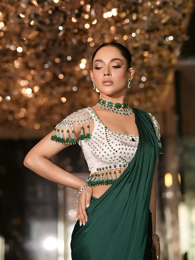 একরঙা শাড়ির সঙ্গে লাইমলাইট চুরি করে নিয়েছে স্টেটমেন্ট ব্লাউজটি। মুক্তা, সাদা–পান্না সবুজ পাথর আর নিখুঁত বিডওয়ার্কে সাজানো পুরো ব্লাউজ তমার গ্ল্যামারকে আরও বহুগুণ বাড়িয়ে তুলেছে।