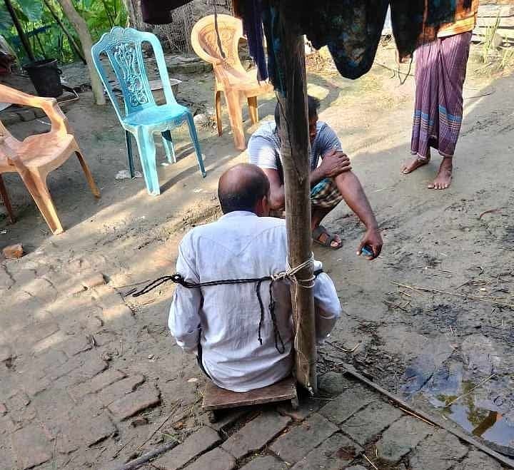 চুক্তি ভঙ্গ করে অন্যের কাছে জমি বিক্রির অভিযোগে এক ব্যক্তিকে খুঁটির সঙ্গে এভাবেই বেঁধে নির্যাতন করা হয়। গত শুক্রবার সকালে সাতক্ষীরার তালা উপজেলার বালিয়া গ্রামেছবি: সংগৃহীত