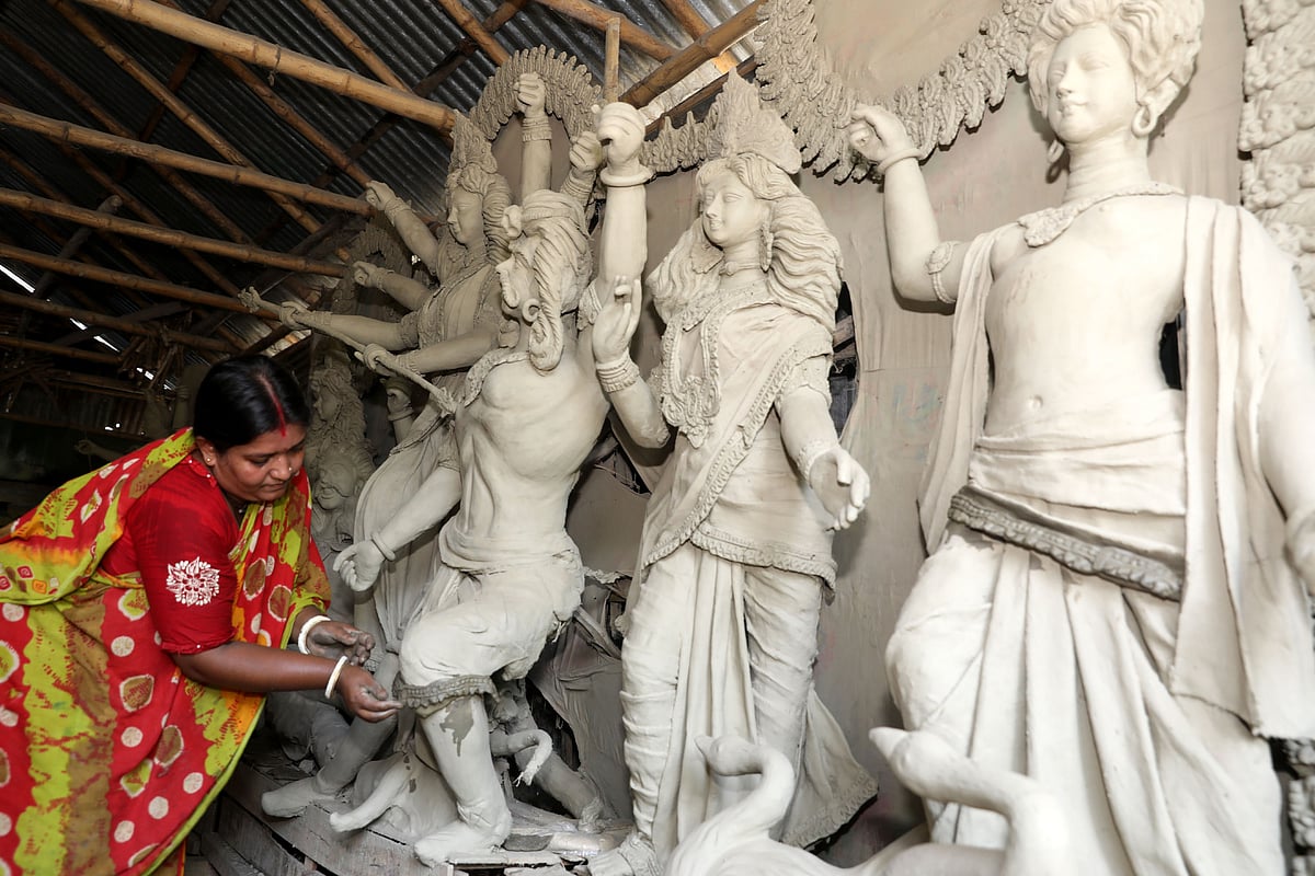 প্রতিমার গায়ে মাটির গয়না বসাচ্ছেন নূপুর মোহন্ত