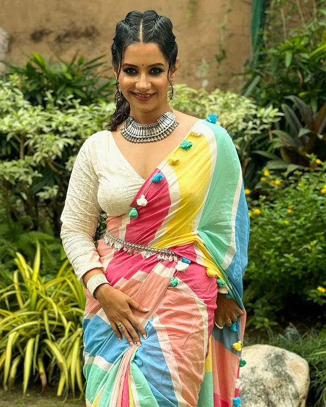 ফুলস্লিভ ডিপনেক অফ হোয়াইট ব্লাউজের সঙ্গে অঙ্গনার বর্ণিল শাড়ি আর অক্সিডাইজড নেকপিস দারুণ মানিয়েছে