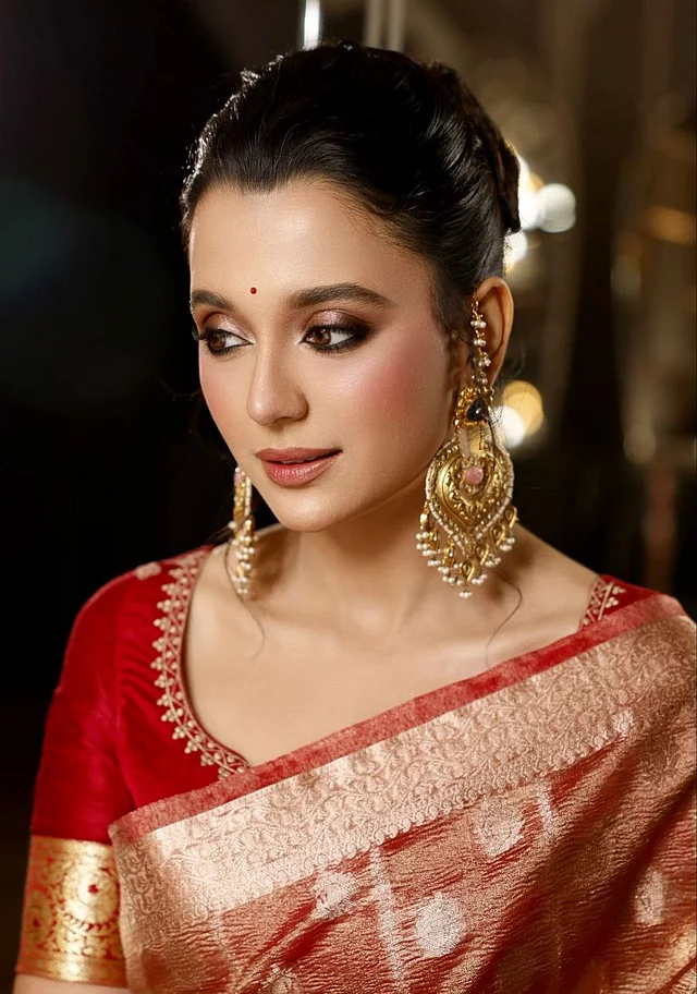 রূপ বিশেষজ্ঞ জাহিদ খানের ফুল গ্ল্যাম মেকওভারে মোহনীয় লাগছেন সাবিলা। ঘন কাজল-মাসকারার ড্রামাটিক আই মেকআপ , ছোট লাল টিপ আর হালকা ব্রিক রেড লিপকালার দেখা যাচ্ছে। 