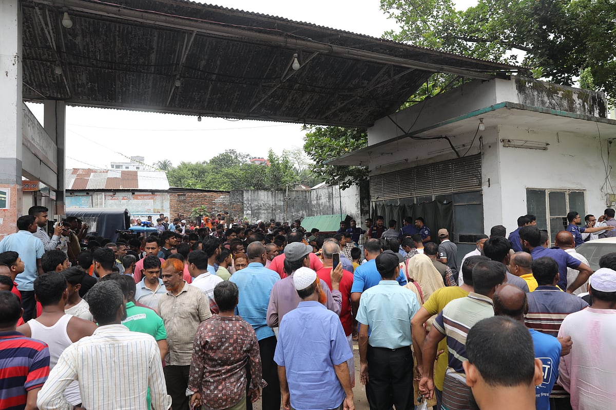 ফিলিং স্টেশনের কর্মকর্তা হত্যার ঘটনায় স্থানীয় বাসিন্দাদের ভিড়। রোববার সকালে বগুড়া শহরের দত্তবাড়ি এলাকায়ছবি: প্রথম আলো