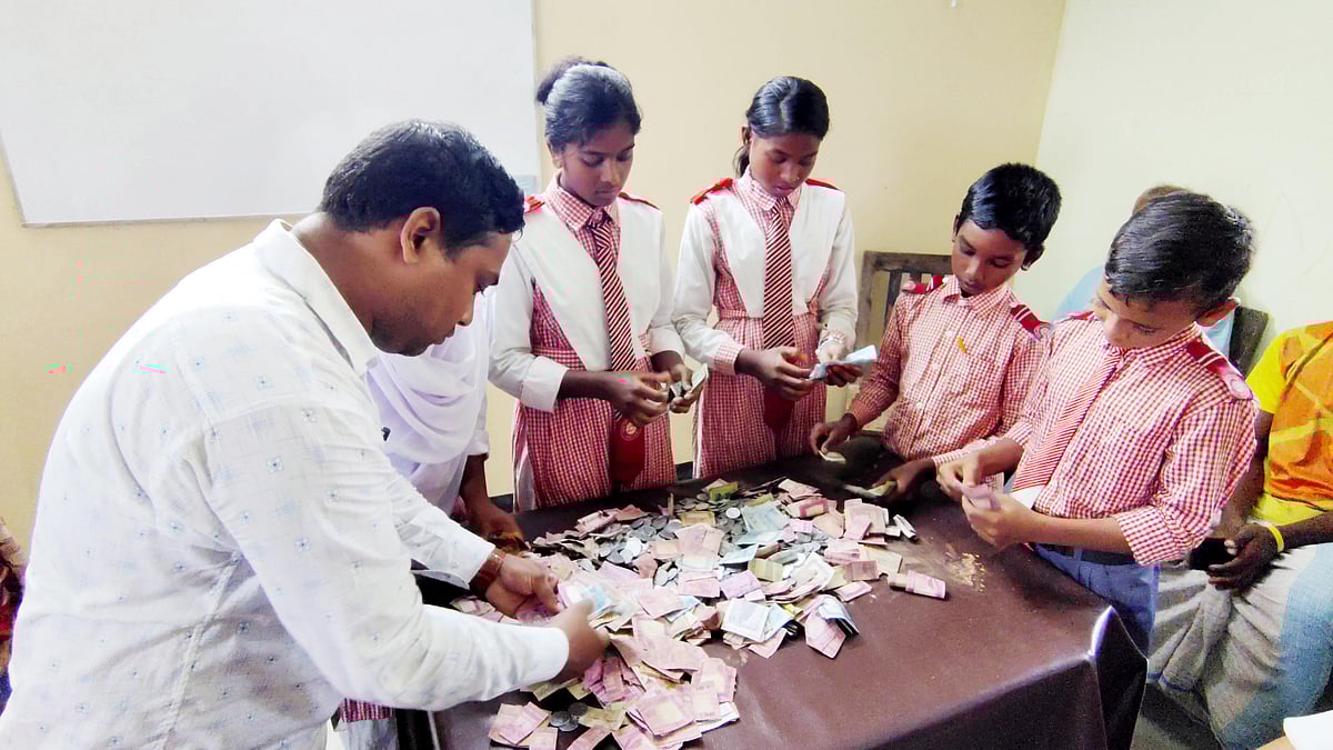 বিদ্যালয়ে মাটির ব্যাংকে জমানো টাকা এক সহপাঠীর মায়ের চিকিৎসায় দিয়ে দিচ্ছে শিক্ষার্থীরা। মাটির ব্যাংক ভাঙার পর টাকাগুলো গুনে নেওয়া হচ্ছে। মঙ্গলবার দুপুরে রাজশাহীর গোদাগাড়ীর বাবুডাইং আলোর পাঠশালায়ছবি: প্রথম আলো