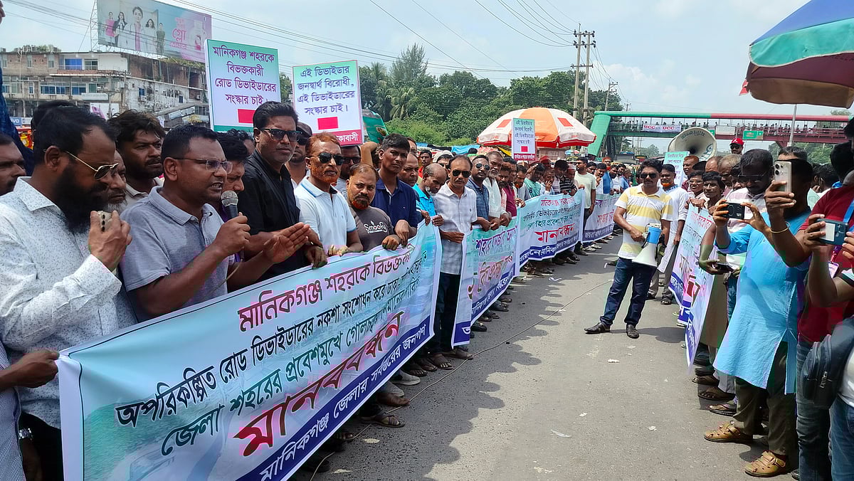 মানিকগঞ্জ বাসস্ট্যান্ড এলাকায় সড়ক বিভাজক অপসারণ করে গোলচত্বর নির্মাণের দাবিতে মানববন্ধন। আজ মঙ্গলবার দুপুরেছবি : প্রথম আলো