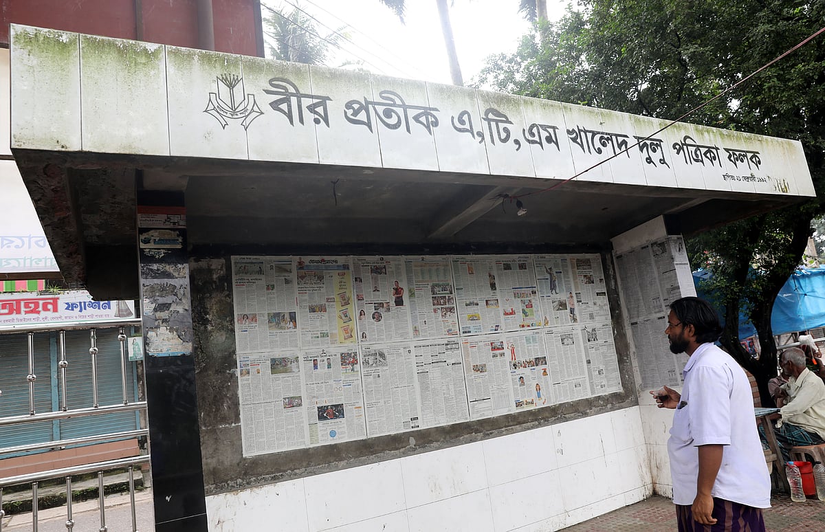 পার্কের ভেতরে দেয়ালে সাঁটানো রয়েছে পত্রিকা। পাঠকেরা সকালেই তা পড়ে ফেলেন। 