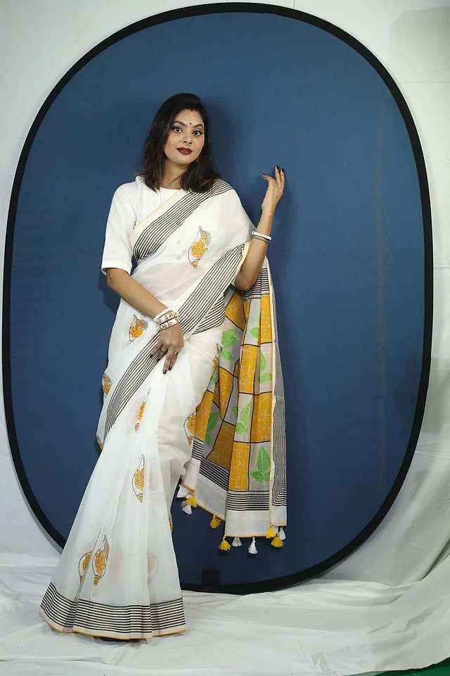 বেলপাতা ও শঙ্খ নকশার মোটিফ দিয়ে স্ক্রিন প্রিন্টে এই শাড়ির জমিন অলংকৃত করা হয়েছে। পূজার ৫ দিনের কোন একদিন সহজেই মানিয়ে যাবে এই শাড়ি।