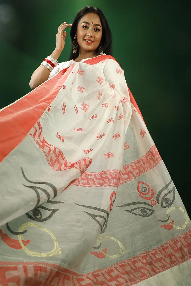 হাফসিল্ক ও মারসেলাইজড কটনের সমন্বয়ে বোনা এই শাড়ির জমিন অলংকরণে মোটিফ হিসেবে ব্যবহার করা হয়েছে স্বস্তিকা ও দেবী দূর্গার মুখাবয়ব। তবে সবচেয়ে আকর্ষণীয় বিষয় হচ্ছে কোনো মাধ্যমে নয় বরং বয়নেই মূর্ত করা হয়েছে এসব মোটিফ। এই বৈশিষ্ট্যই মিতার গল্পের এই শাড়িসংগ্রহকে করেছে স্বতন্ত্র।