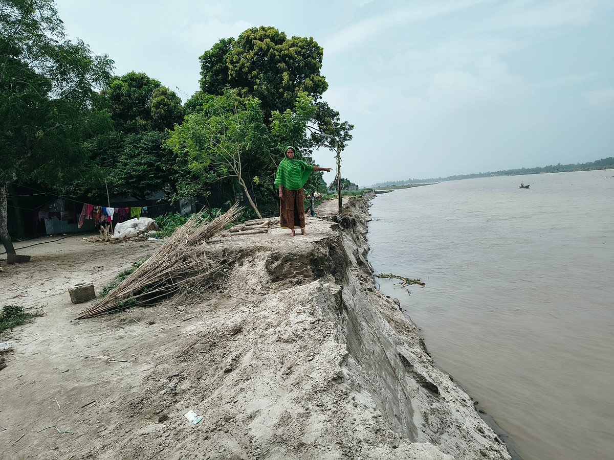 শেরপুরের সদর উপজেলার ব্রহ্মপুত্র নদে বিলীন হয়ে যাওয়া বসতভিটা দেখাচ্ছেন এক নারী। গতকাল মঙ্গলবার দুপুরে ভাগলঘর গ্রামেছবি: প্রথম আলো
