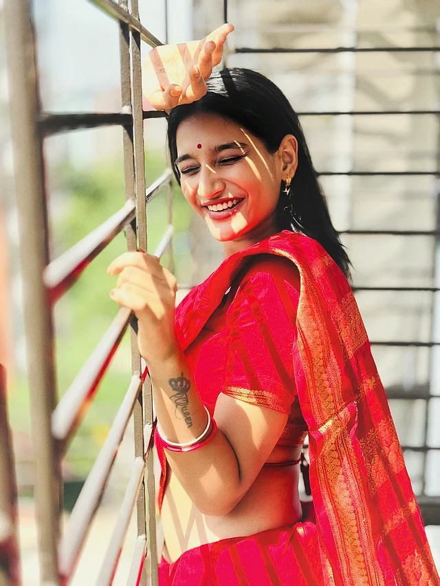 নিদ্রা এই লুকে কানে পরেছেন ছোট্ট সোনার দুল আর হাতে পরেছেন লাল চুড়ি।