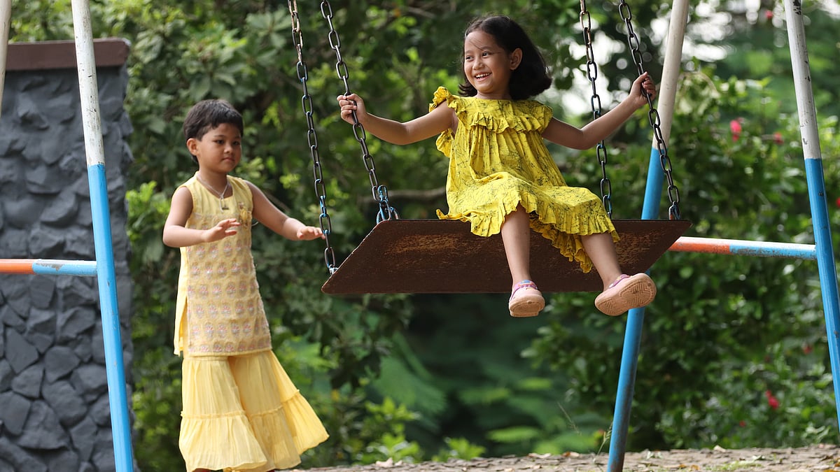 দোলনায় দোল খেতে খেতে আনন্দে মেতেছে দুই শিশু