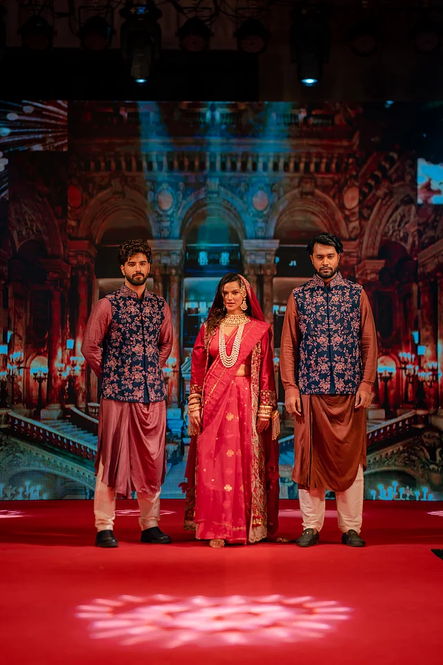 ভিভা ক্রিয়েশন তুলে ধরে তাদের নতুন ব্রাইডাল কালেকশন। এখানে ব্রাইডকে দেখা যাচ্ছে লাল জামদানিতে। ওপরে লেয়ার করেছেন ম্যাচিং জ্যাকেট। অন্যদিকে ছেলেদের পরনে এসিমেট্রিক পাঞ্জাবি ও ফ্লোরাল কোটি। 