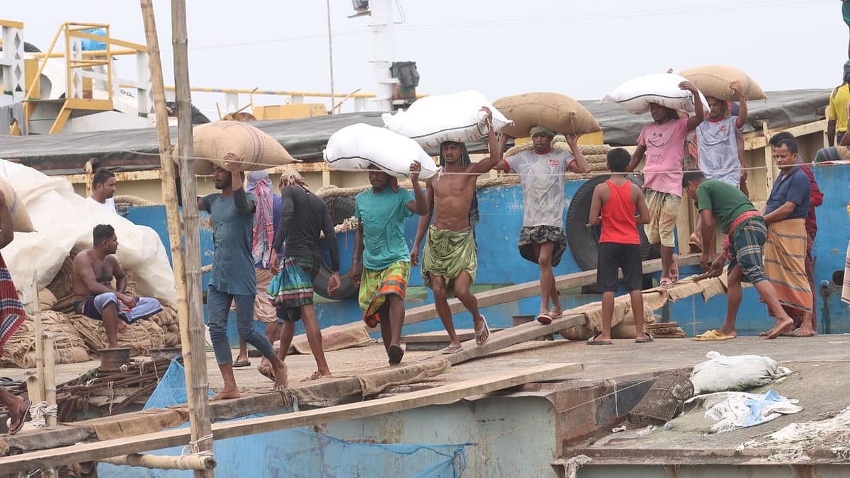 জীবিকার তাগিদে কার্গো ট্রলার থেকে মালামাল খালাস করছেন পদ্মাপাড়ের শ্রমজীবীরা