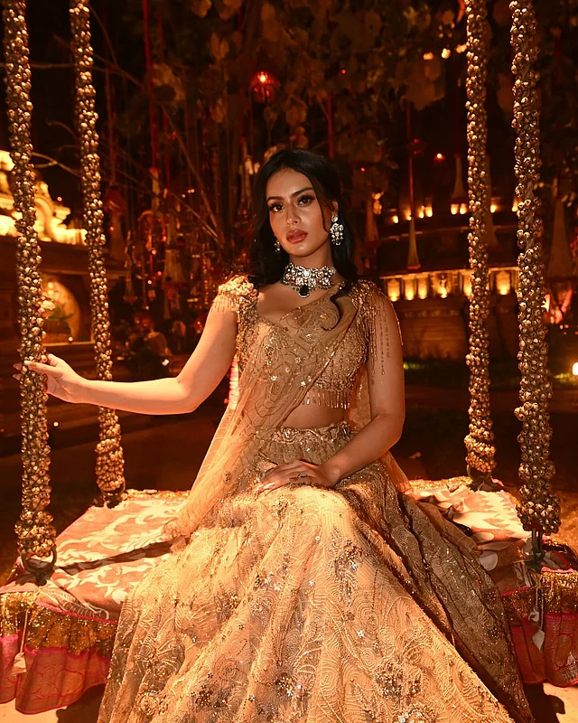 ঝলমলে সোনালি লেহেঙ্গাইয় আলো-আঁধারিতে দোলনায় বসে আছেন তিনি