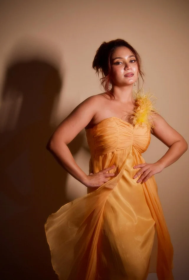 বাসন্তী রঙের ওয়ান শোল্ডার গাউনে দেখা যাচ্ছে এই নাচের মেয়েকে