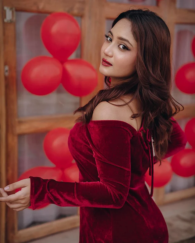 এখানে তাঁকে দেখা যাচ্ছে মেরুন ভেলভেট অফ দ্য শোল্ডার ড্রেসে