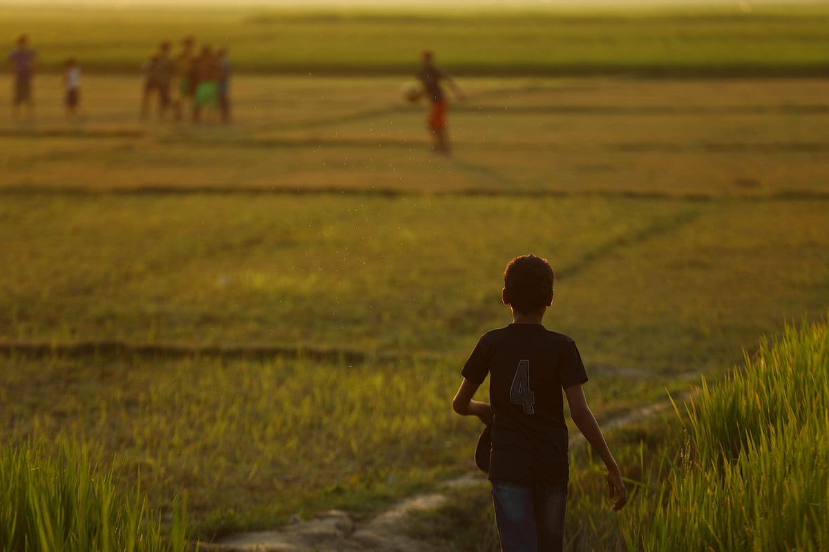 ফুটবল খেলতে যাচ্ছে এক শিশু 