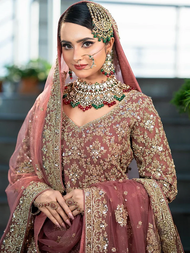 এখানে এক পাশে সিঁথি করা চুলে টেনে বেঁধে খোঁপা করা হয়েছে পরিপাটি স্টাইলে। সঙ্গে আছে ভারি জড়োয়া সেটের দুল, চোকার, টানা নথ, ঝাপটা আর রতনচূড়