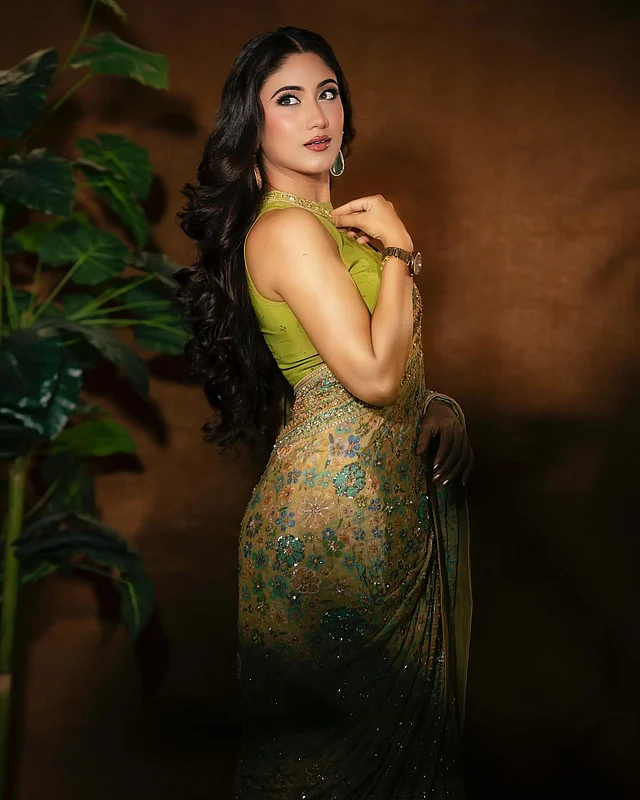 শাড়িতে নারী বরাবরই সুন্দর। বাংলাদেশী অভিনেত্রী সাফা কবির এই লুকে পরেছেন ফ্লোরাল প্রিন্টের হালকা অলিভ শাড়ি। শাড়িজুড়ে সোনালি, ফিরোজা, সবুজ ও কপার টোনের সূক্ষ্ম হ্যান্ড এমব্রয়ডারি, সঙ্গে ঝলমলে সিকুইনের কাজে ফুটে উঠেছে রাজকীয় দীপ্তি। সঙ্গে মানানসই লাইম অলিভ রঙের ব্লাউজটি স্লিভলেস ও হাই-নেক ডিজাইনের। সোনালি জড়িসুতা আর সিকুইনের নেকলাইনটিও আকর্ষণ কাড়ছে। 