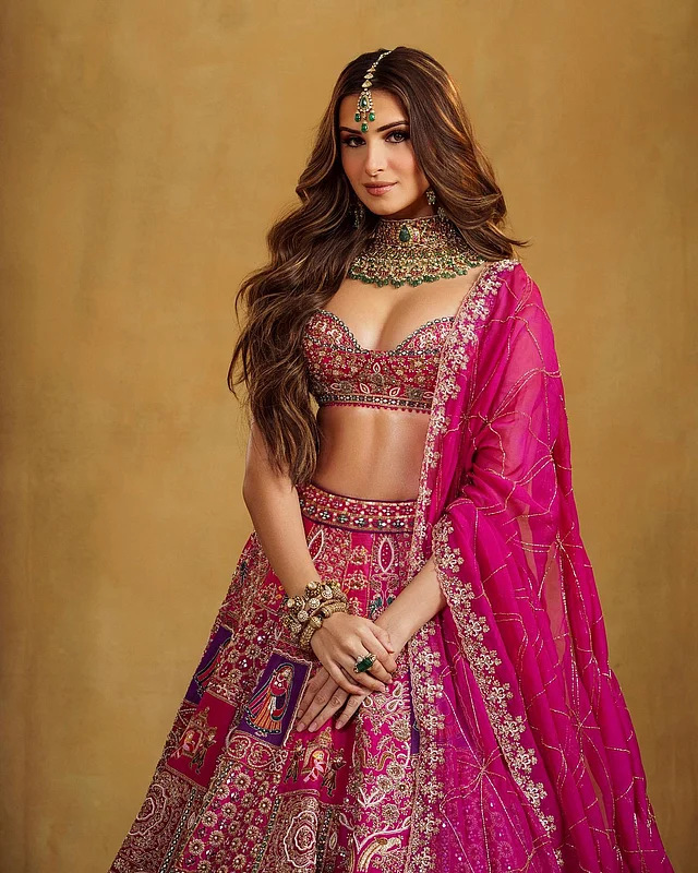 তারা বেছে নিয়েছেন হালকা গোলাপি লেহেঙ্গা, যার বেগুনি নকশা ও সূক্ষ্ম কারুকাজে এসেছে রাজকীয় আভা