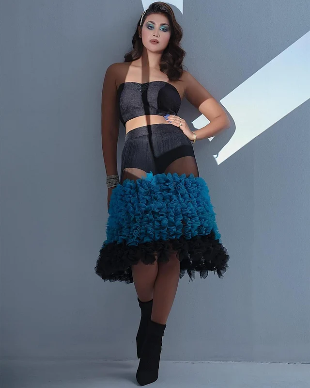 স্ট্র্যাপলেস কালো ক্রপ টপের সঙ্গে মেঘলার এই লুকে জুটি হয়েছে শিয়ার ফেব্রিকের নীল–কালো রাফেল স্কার্ট। 