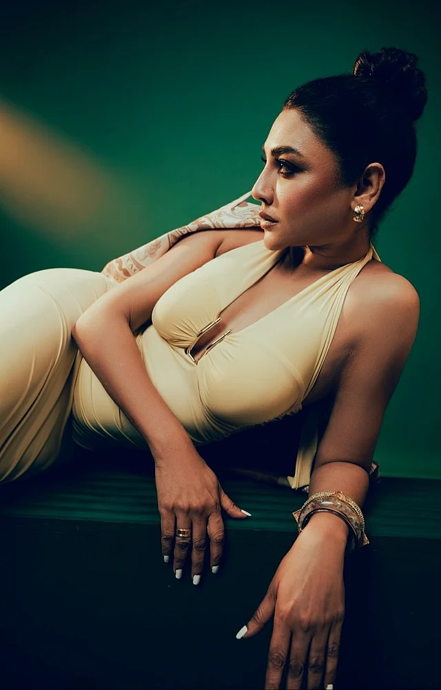 ডিপনেক ড্রেসের সঙ্গে চূড়া খোঁপা আর স্মোকি আইজের সঙ্গে ডার্ক মেকওভার দেখা যাচ্ছে