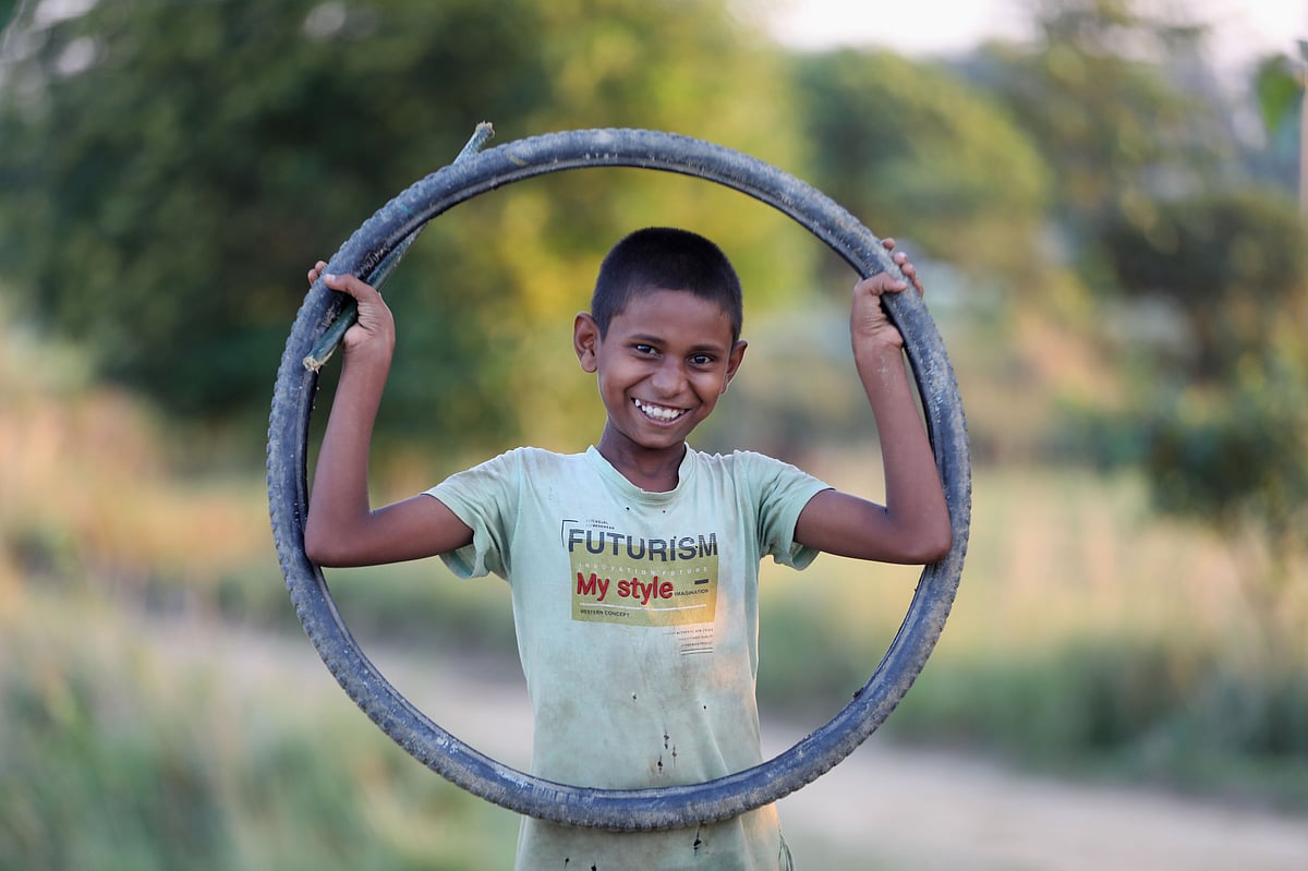 ফেলনা টায়ার হাতে হাসিমুখে এক শিশু  