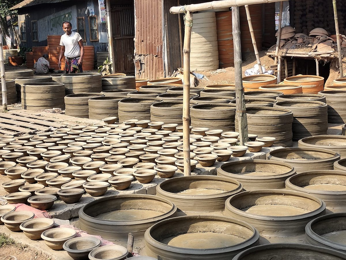 দইয়ের পাত্র বা সরা এবং শৌচাগারের জন্য মাটির তৈরি পাট রোদে শুকাতে দিয়েছেন কুমোরেরা 