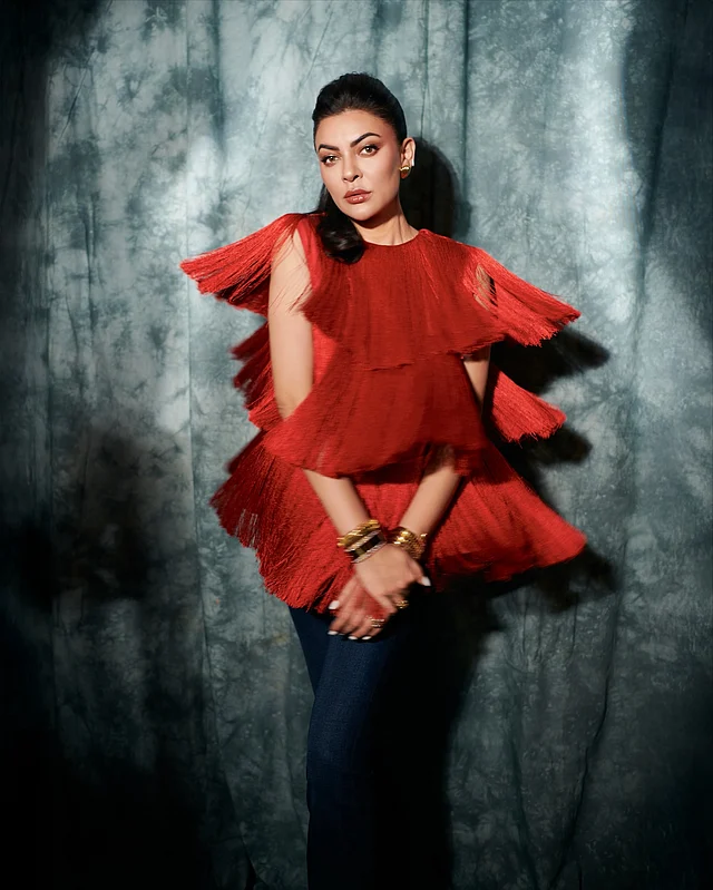 লাল ফ্রিঞ্জড ডিটেইলিং ফ্লেয়ার টপের সঙ্গে ডেনিম প্যান্ট জুটি হয়েছে এই লুকে 