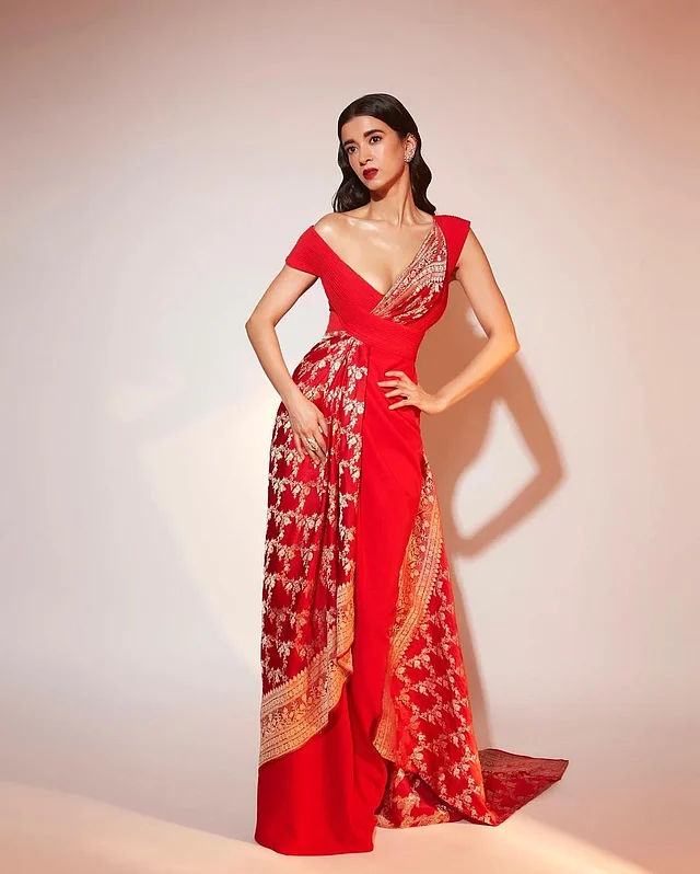 ভিনটেজ লাল বেনারসির পোশাকটি দেখে কখনো মনে হবে বিয়ের কনের লাল টুকটুকে শাড়ি, আবার মনে হবে গাউনও। এটাই ডিজাইনারের কারসাজি।