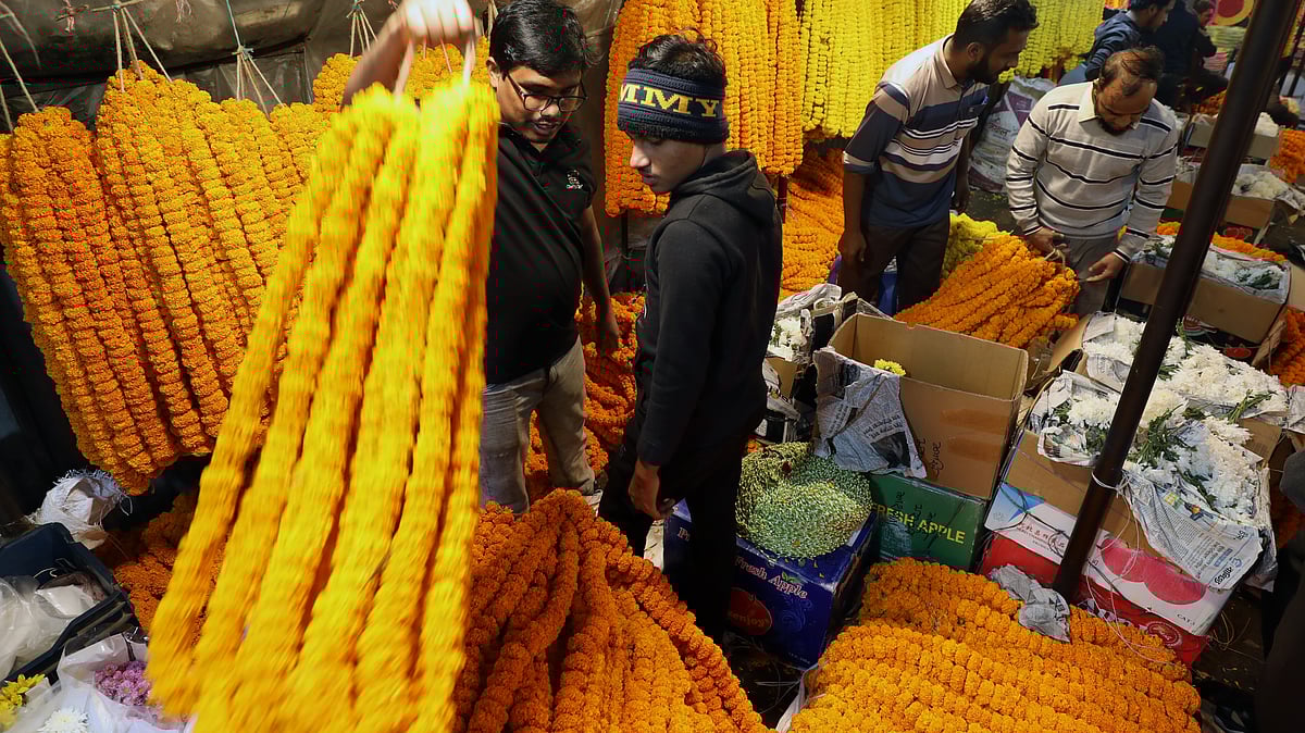 ক্রেতাদের গাঁদা ফুলের মালা দেখাচ্ছেন বিক্রেতারা।