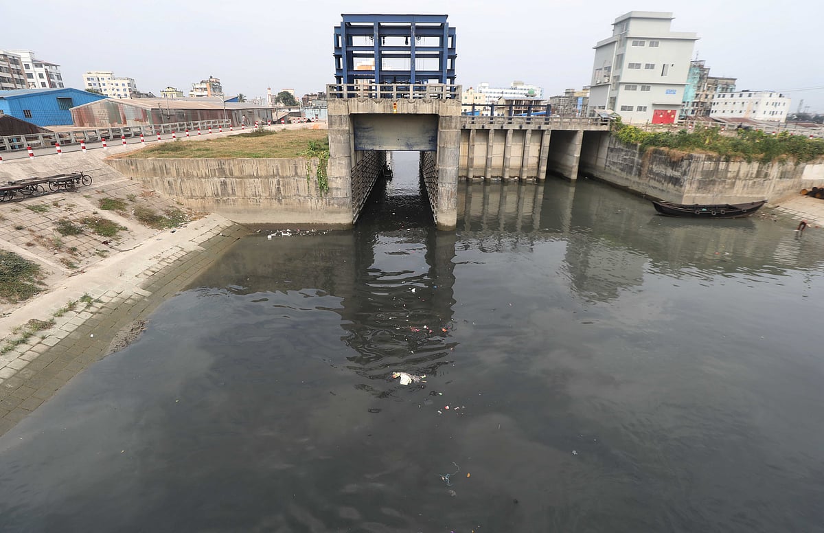 কলকারখানার বর্জ্যে দূষিত কালো পানি স্লুইসগেট দিয়ে বেরিয়ে আসছে 