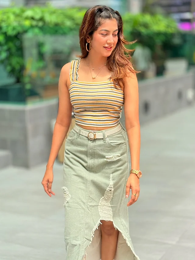 এখানে তিনি পরেছেন ট্যাংক টপ  আর ডিস্ট্রেসড ডেনিম স্কার্ট