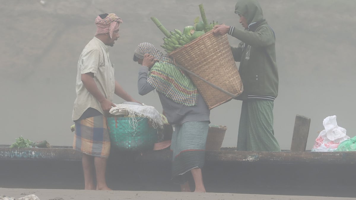 কুয়াশামাখা সকালে ঝুড়িভরা কলা নামানো হচ্ছে
 