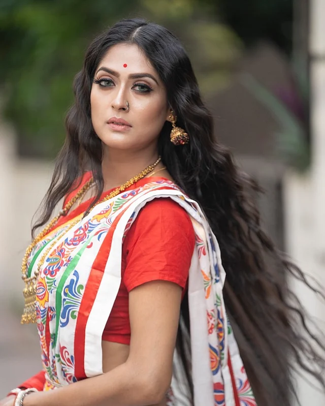 এখানে এক ঢাল খোলা চুলের সঙ্গে বাঙালি সাজের লাল-সাদা শাড়িতে আকর্ষণ ছড়াচ্ছেন পূর্ণিমা