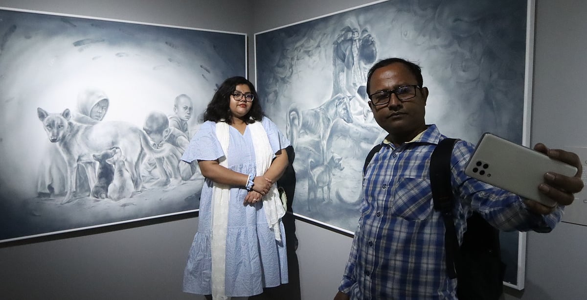  ‘রোয়া-দ্ব’ প্রদর্শনীতে পছন্দের চিত্রকর্মের সঙ্গে সেলফি তুলছেন দুজন। ক্ষুদ্র নৃগোষ্ঠী সাংস্কৃতিক ইনস্টিটিউট গ্যালারি, বান্দরবান