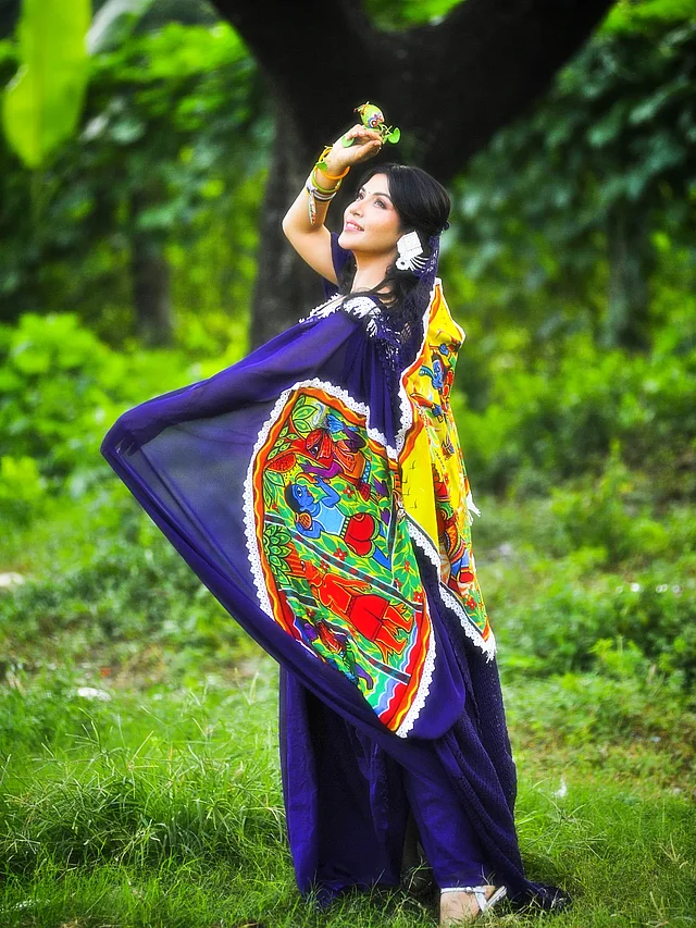 রঙিন মোটিফে নীলা শাড়িতে সেজেছেন তিনি সবুজ প্রকৃতির মাঝে