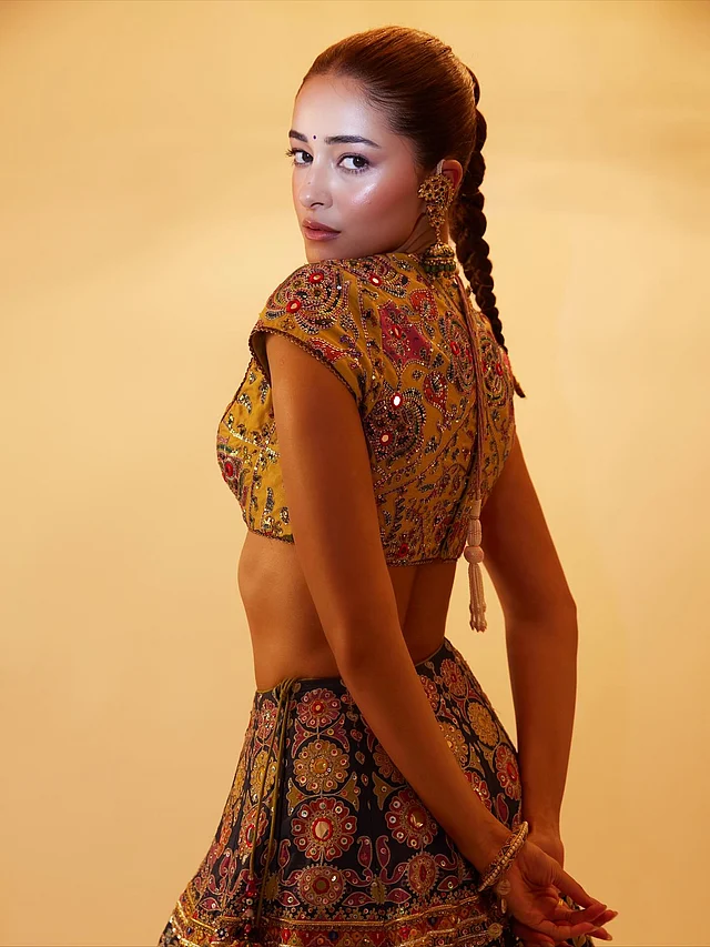 মডার্ন ব্রাইডসমেইড লুকে অনন্যা। ক্রপ টপের সঙ্গে পরেছেন জুয়েল টোনের ঘেরওয়ালা স্কার্ট। মাল্টিকালার লেহেঙ্গায় ফুটে উঠেছে ফ্লোরাল নকশার সূক্ষ্ম হ্যান্ড এমব্রয়ডারি, মিরর ও সিকুইনের কাজ। 